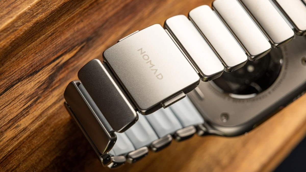 Макрознімок титанового годинника Apple Watch з ремінцем 'Icy Blue Glow' на дерев'яному столі.