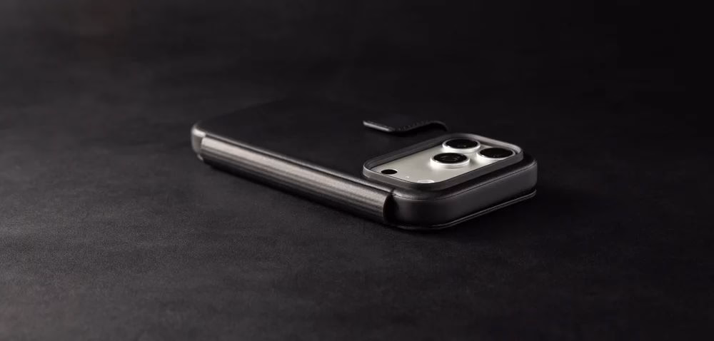 Чехол Nomad Modern Folio Horween Black лежит на темном фоне