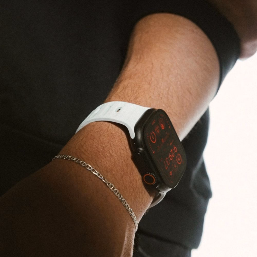 Світло-блакитний ремінець Nomad Sport Band Icy Blue Glow на зап'ясті руки в кишені, стильний вигляд Apple Watch Ultra 2 у повсякденному образі