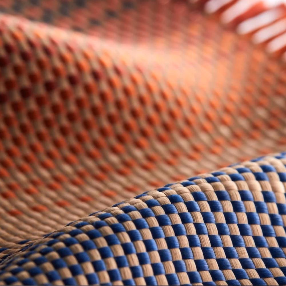 Макрофотография фирменного цветного плетения Fusion Weaving из ультрапрочного арамидного волокна пауэрбанка Pitaka Aramid Fiber Qi2 10000mAh Sunset