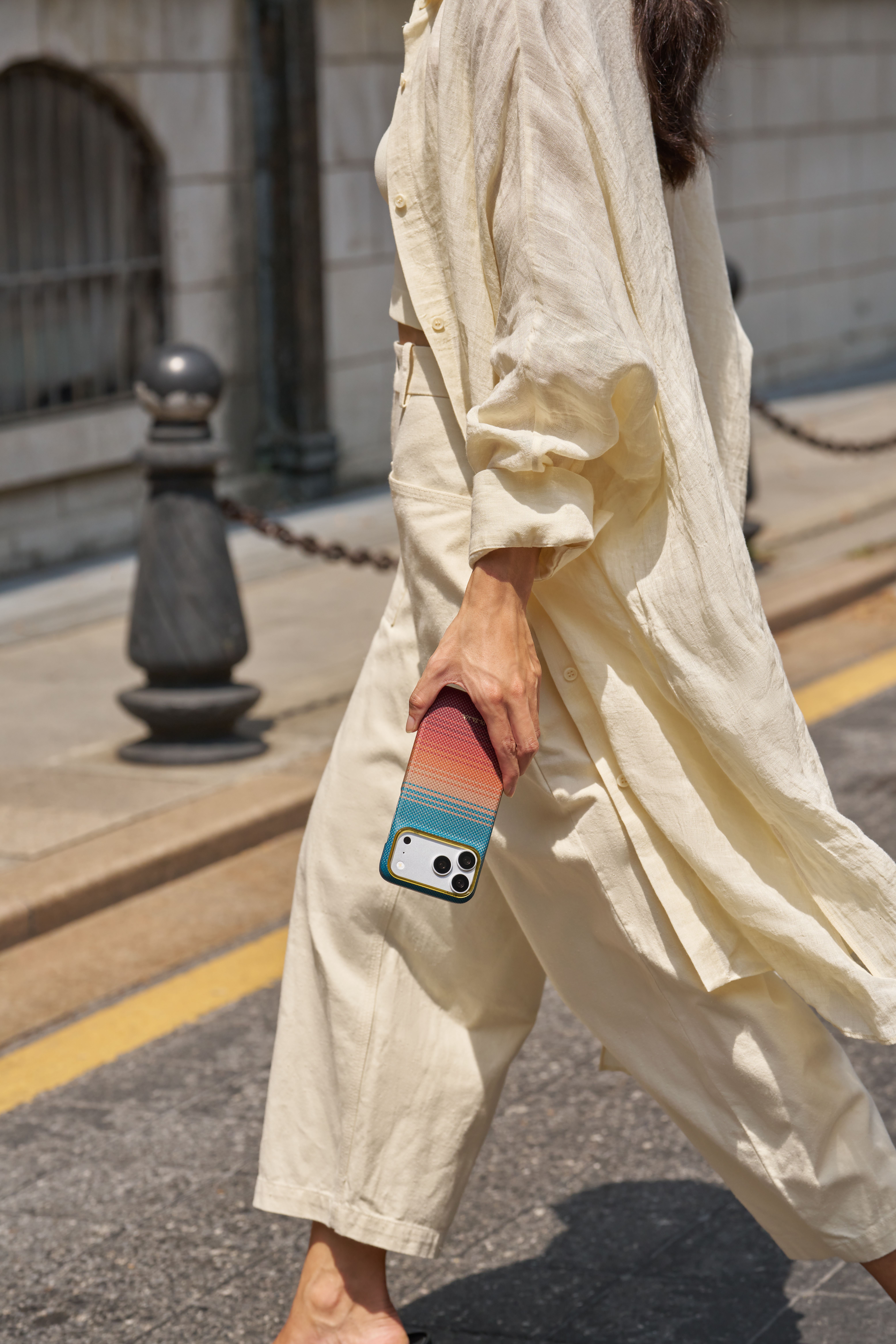Женщина идет с iPhone в чехле Pitaka Edge California Dream
