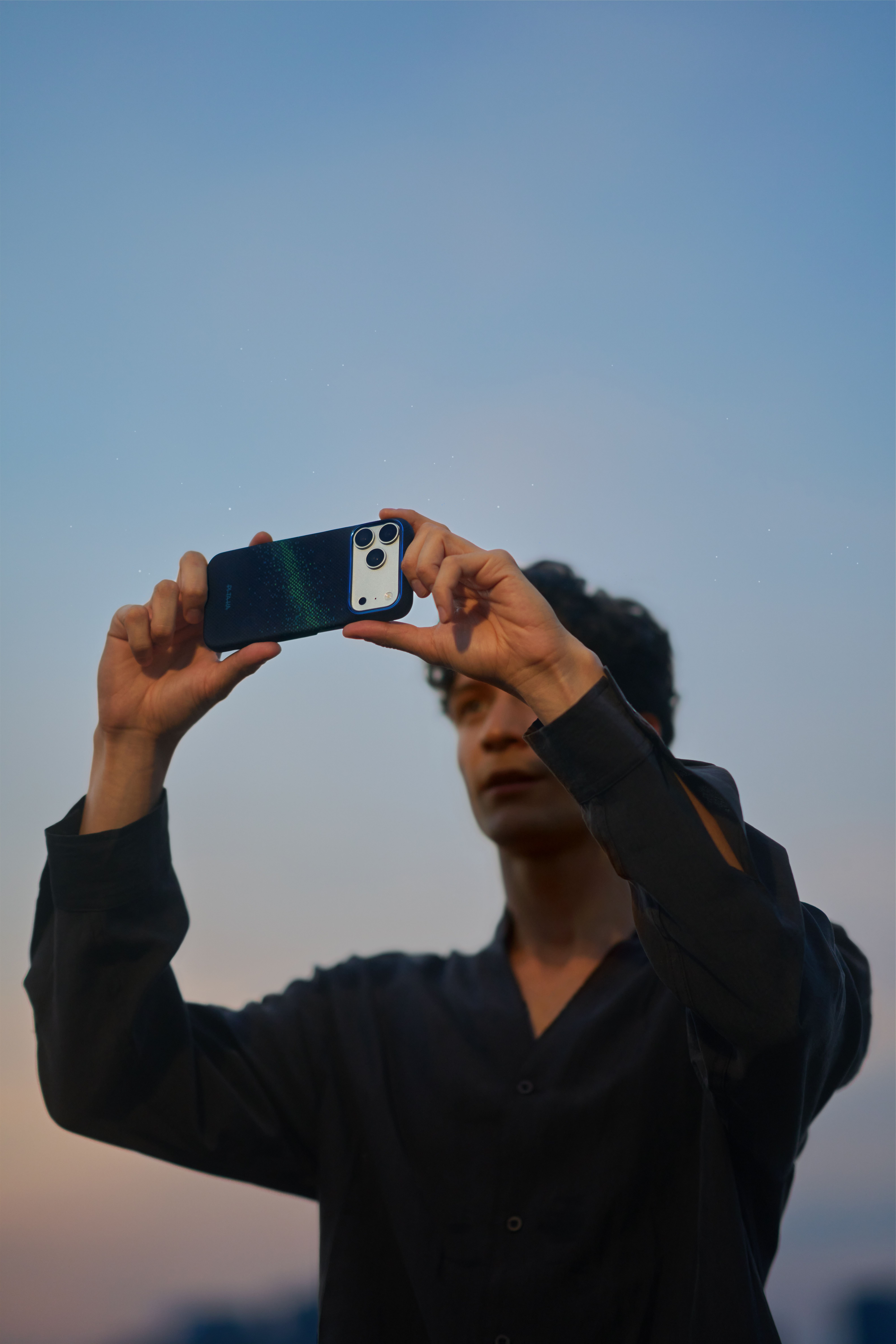 Мужчина фотографирует на iPhone в чехле Pitaka Edge