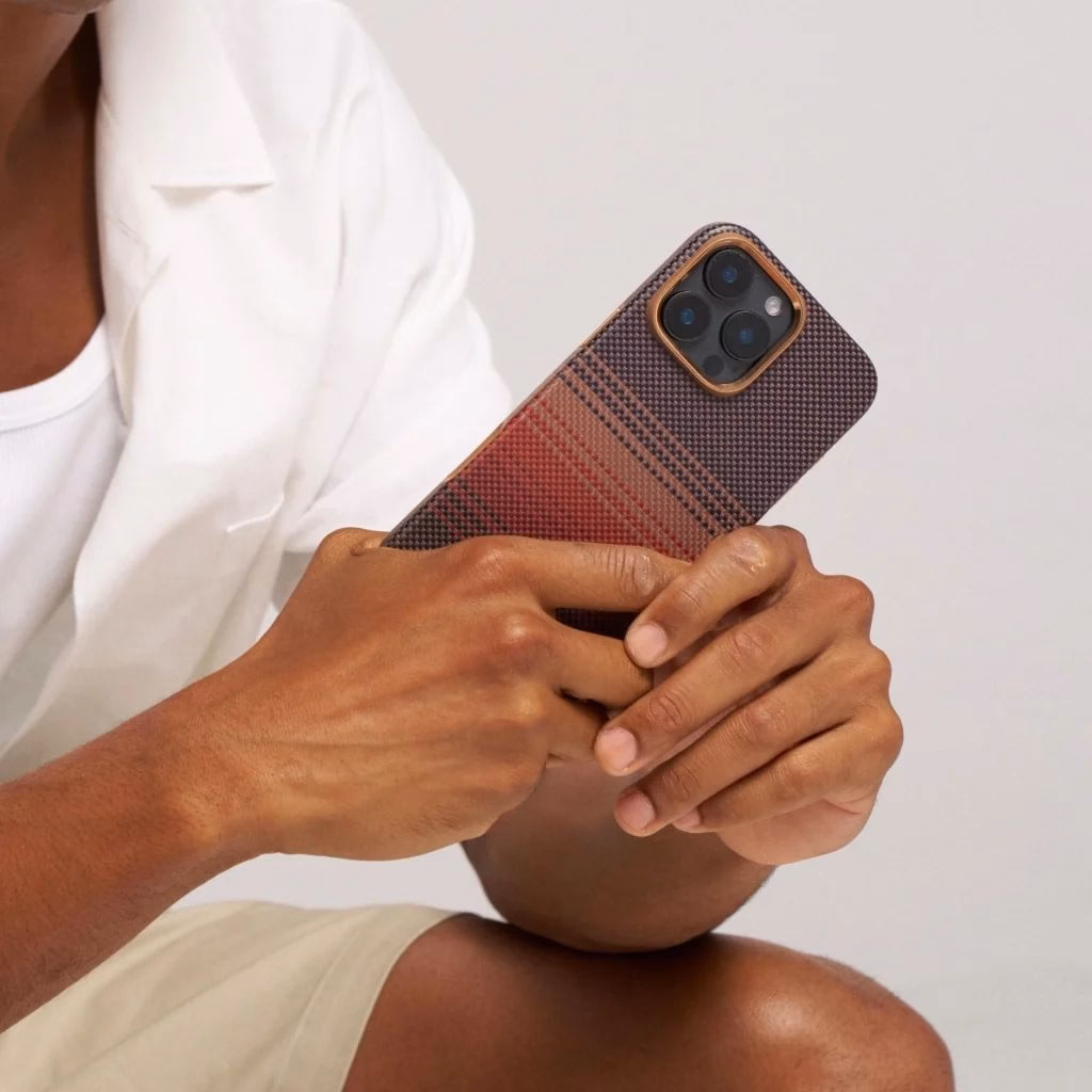 Мужчина держит iPhone 16 Pro в чехле Pitaka Summa Sunset