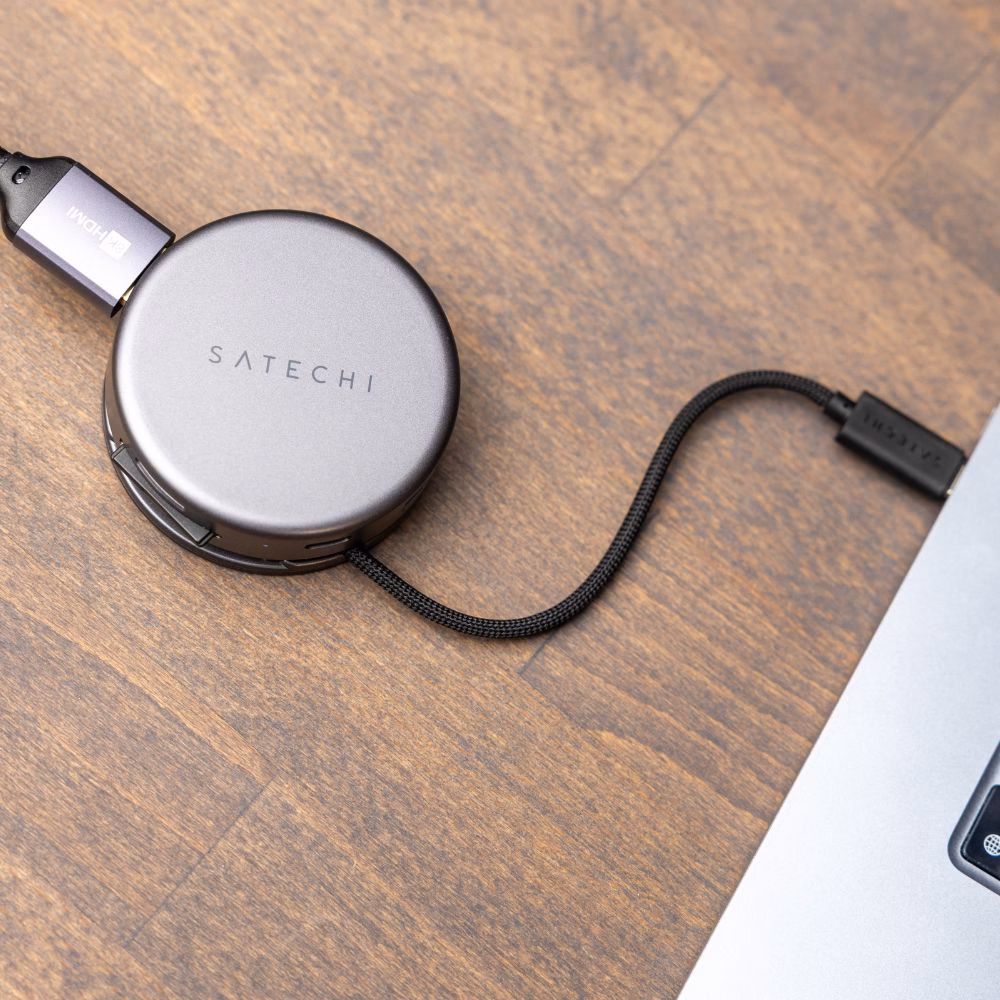USB-C хаб Satechi на деревянной поверхности, подключенный к MacBook через прочный плетеный кабель, выход HDMI для монитора