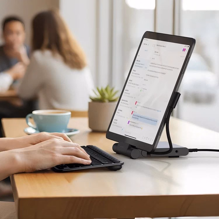 Мужчина работает с iPad и клавиатурой на подставке Satechi в кафе