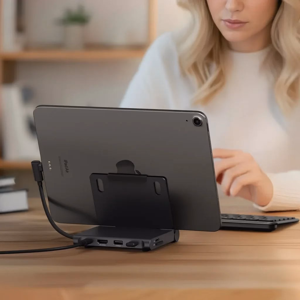 Женщина работает на iPad за столом в кабинете, вид сзади