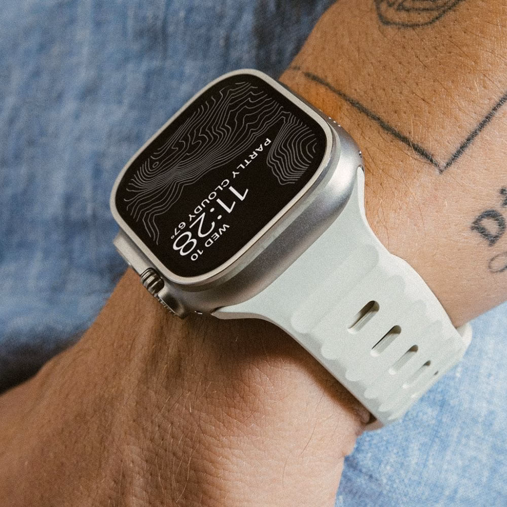 Силіконовий ремінець Nomad Sport Band у білому кольорі для Apple Watch Ultra на руці користувача, макрофото текстури та кріплення