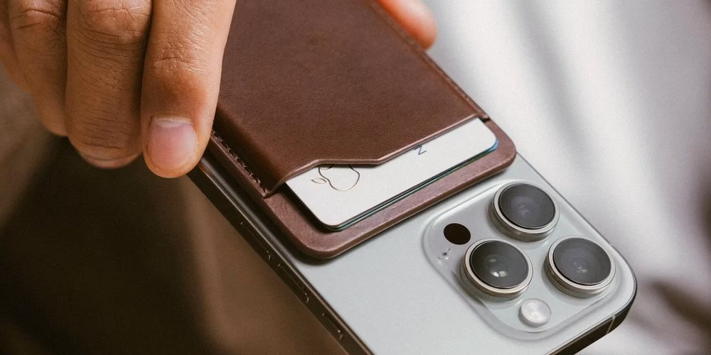 Кошелек Nomad Leather Mag Wallet Camino Brown крупным планом на смартфоне в руке