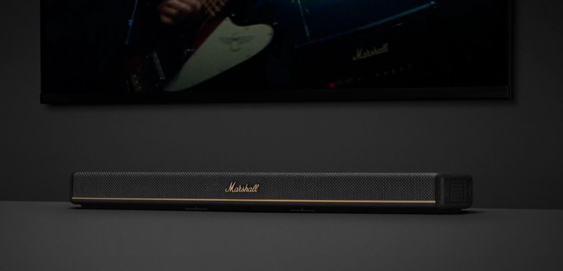 Акустична панель Marshall Heston на полиці під телевізором, акцент на текстурі гриля та логотипі бренду