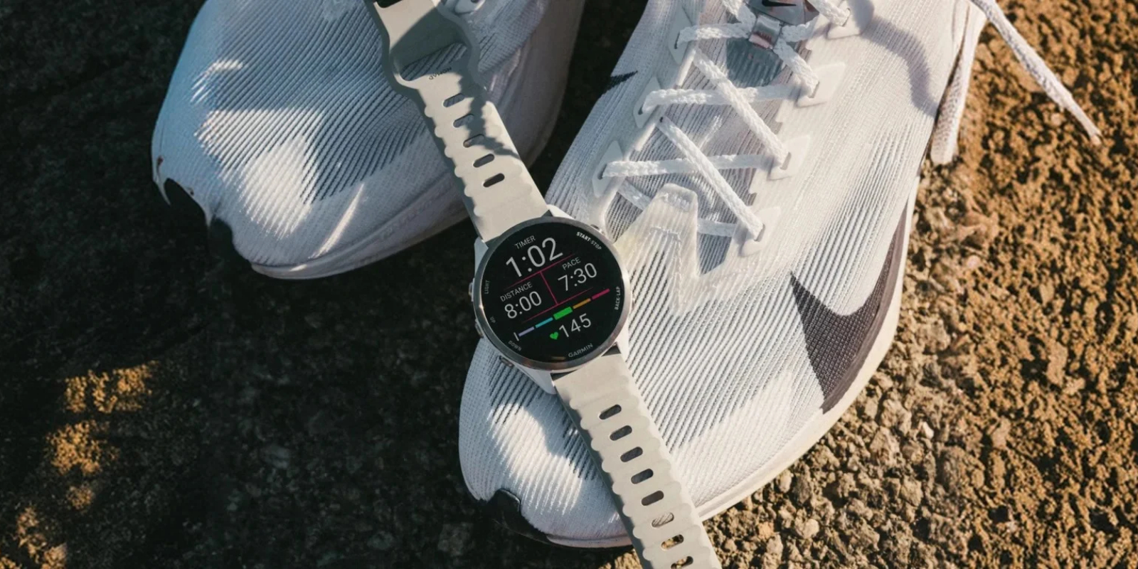 Білий ремінець Nomad Sport Band 22 мм на годиннику Garmin поруч із біговими кросівками